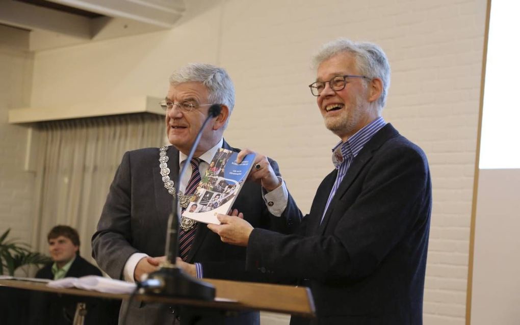 Burgemeester Van Zanen (Utrecht) ontving gisteren uit handen van Albert Luiks, secretaris van de redactie, een kerkengids.  beeld Kerk in Actie