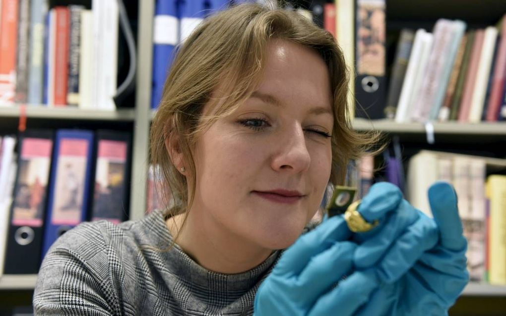 Promovenda Nelleke IJssennagger onderzoekt een sieraad uit de Vikingentijd. Ze promoveerde donderdag op de ingewikkelde relatie tussen Friezen en Vikingen. beeld Marchje Andringa