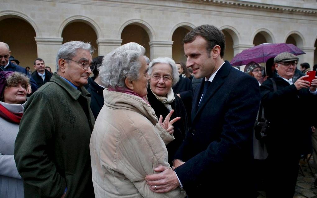 De Franse president Emmanuel Macron in gesprek met burgers bij het Hotel des Invalides in Parijs, maandag. beeld AFP, Thibault Camus