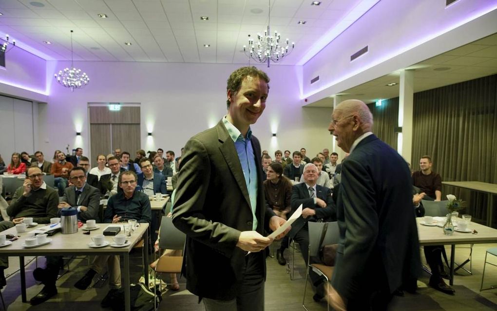 Matthias Mangold (m.) ontving vrijdag in Nijkerk uit handen van prof. dr. W. Balke (r.) de scriptieprijs van de Gereformeerde Bond in de Protestantse Kerk in Nederland. beeld Jaco Klamer