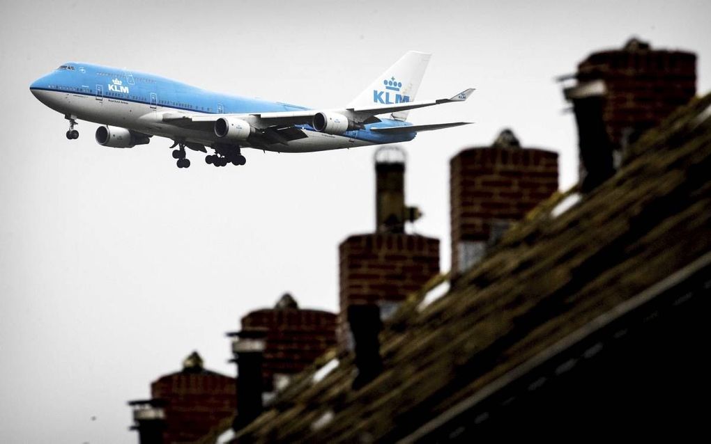 Een Boeing 747 van KLM scheert laag over de bebouwing rond de luchthaven Schiphol. De luchtvaartmaatschappij moet meer ruimte bieden aan concurrenten op de vliegroutes naar New York. beeld ANP, Koen van Weel