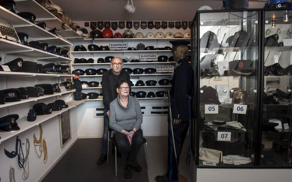 Medewerkers Bert en Titia Hulshof in het politiepettenmuseum in Slochteren. Daar zijn zo’n 1850 hoofddeksels te zien.  beeld Reyer Boxem