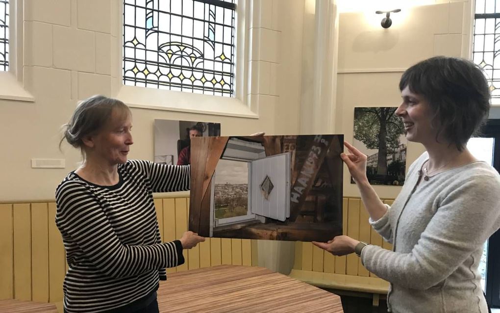 Geertina Hendriksen (links) en ds. Jantine Heuvelink laten een foto uit het boek van Kreijns over de Oranjekerk zien, genomen vanuit de toren en met uitzicht op het Sarphatipark.  beeld RD