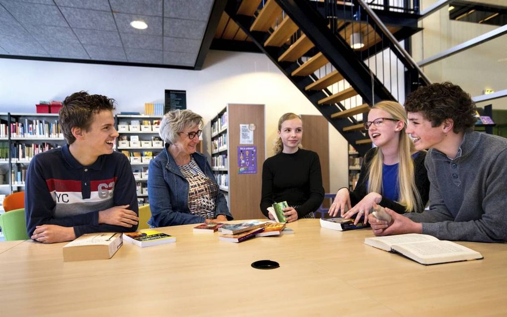 „Bij alle schoolvakken is leesvaardigheid van groot belang.” Archieffoto: docente Rian Vogel-de Pagter spreekt met enkele leerlingen over het lezen van boeken. beeld Dirk Hol