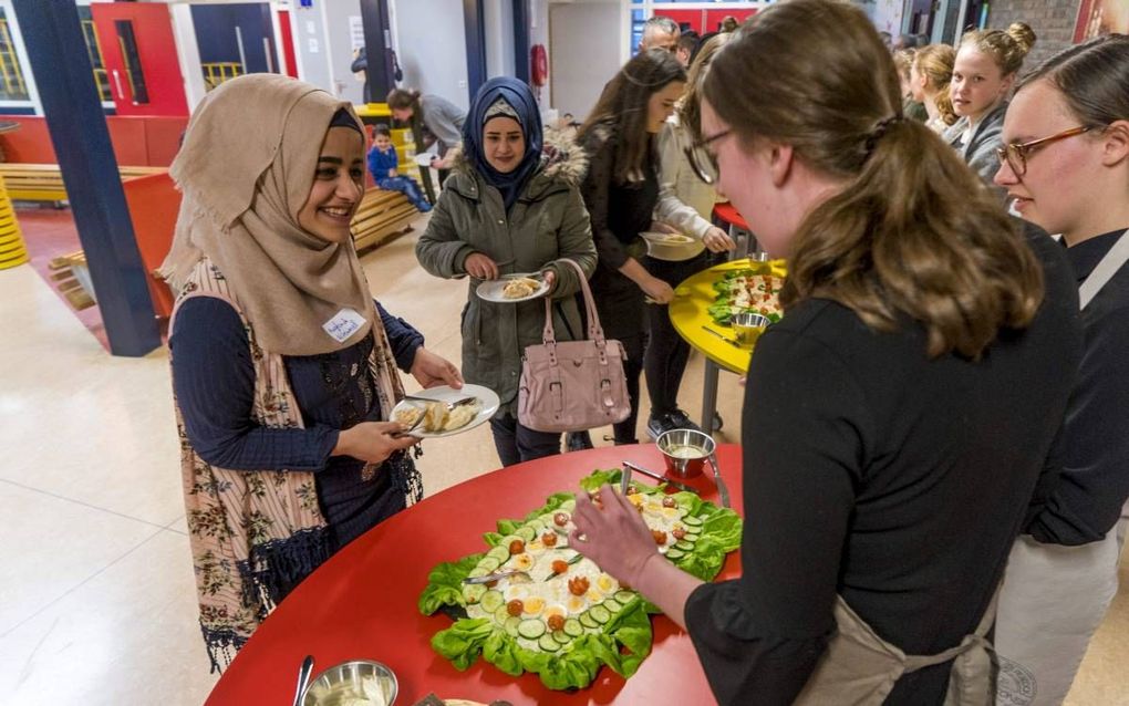 Raghad Alkamel (20) informeert naar de Hollandse pot. De Syrische was een van de ongeveer dertig statushouders die woensdag het Driestar College in Lekkerkerk bezocht voor een interculturele ontmoeting. beeld Cees van der Wal