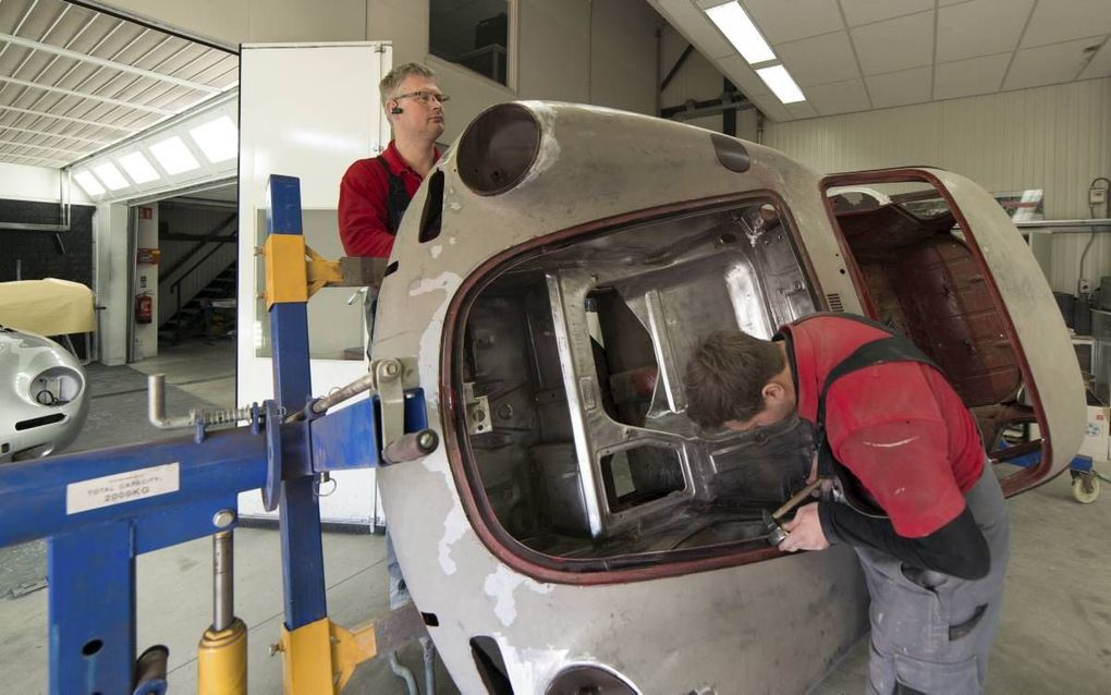 Wim de Weerd (l.) en zijn zoon Gerrit werken aan een Porsche 356 in de werkplaats in Oldebroek. Er komen naast liefhebbers ook investeerders over de vloer bij de restaurateur. beeld Bram van de Biezen