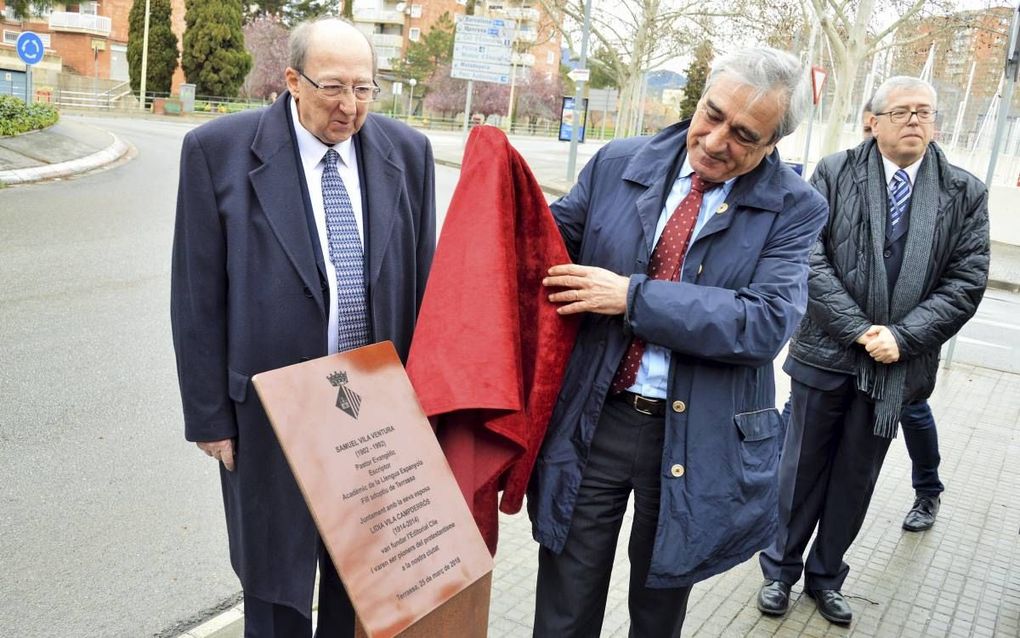 Geflankeerd door zoon Eliseo Vila (l.) en plaatselijk predikant Andreu Dionis (r.), onthult burgemeester Alfredo Vega van Terrassa een plaquette ter herinnering aan het Spaanse predikantsechtpaar Samuel en Lidia Vila.  beeld Jordi Torrents