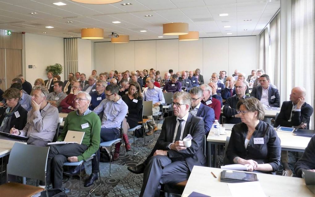 Bezoekers van de conferentie vrijdag in Nijkerk, over spanningen in kerkelijke gemeenten rond de positie van de predikant. Linksvoor een van de inleiders, prof. dr. M. J. Kater. beeld RD