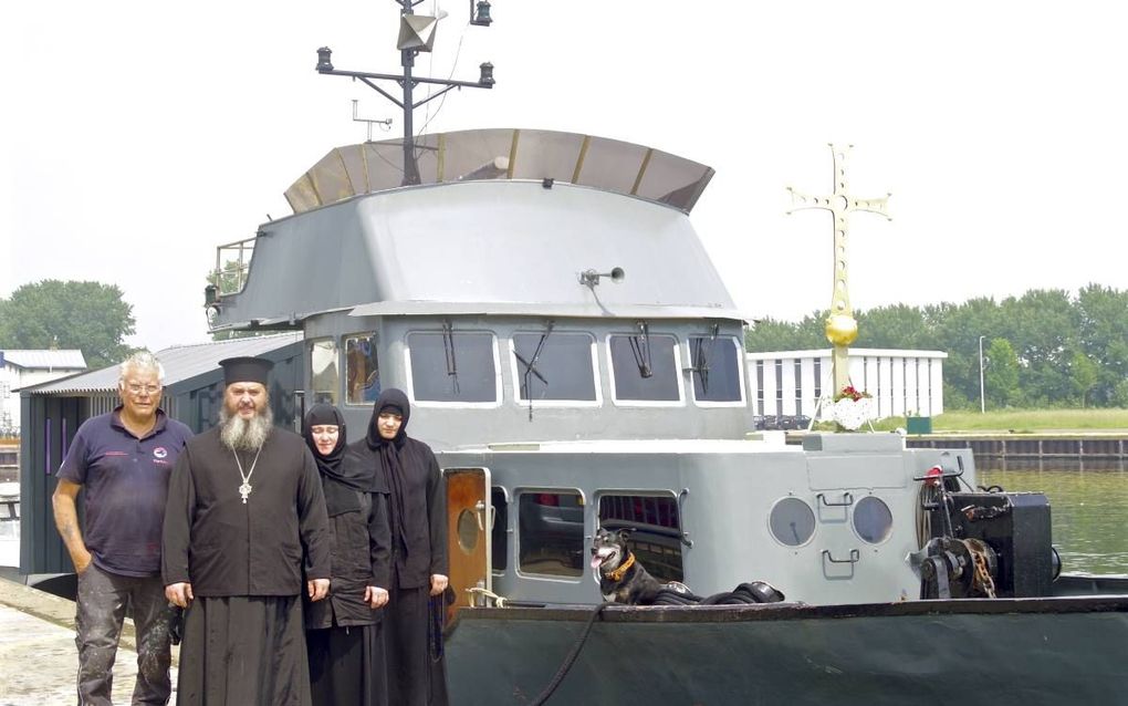 Vader Abibos, moeder Elisabeth en zuster Nino willen met hun varende kapel Elia II georgisch-orthodoxe gelovigen in Europa bereiken. De kapel ligt nu in Vlissingen. Links staat Wout Groen die het drietal helpt.  beeld Van Scheyen Fotografie