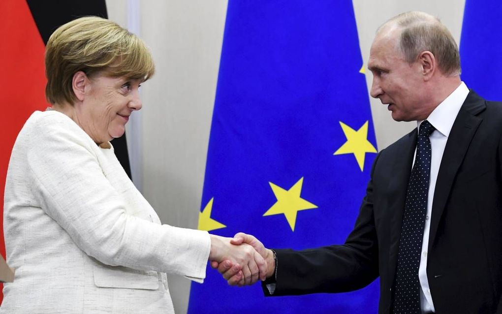 De Russische president Vladimir Poetin (r.) schudt de hand van de Duitse bondskanselier Angela Merkel tijdens hun overleg op 18 mei. beeld AFP, Kirill Kudryavtsev