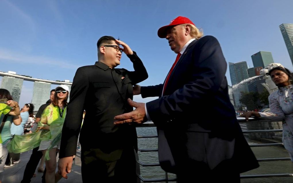 Kim Jong-un heeft in Howard X (l.) een perfect lijkende dubbelganger en ook Trump heeft er een: Dennis Alan (r.). Beiden waren vrijdag in Singapore, maar dinsdag tijdens de top worden ze door de politie op afstand gehouden.  beeld EPA, How Hwee Young.