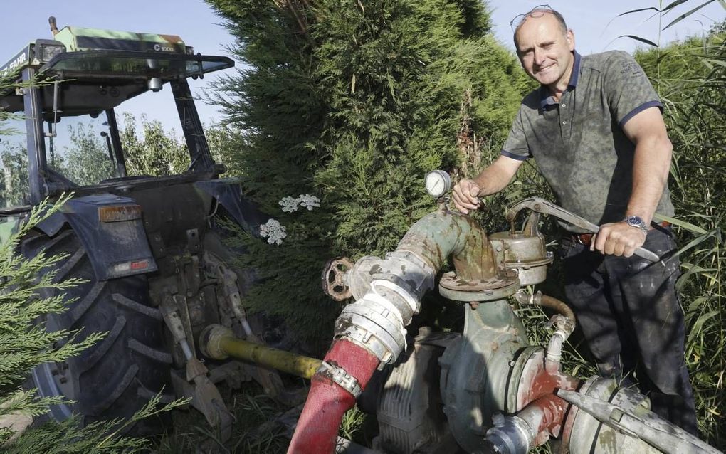 Fruitteler Thomas de Vree uit Dodewaard pompt water uit de gevulde sloot naast zijn boomgaard. Om de grond nat genoeg te houden, moet hij regelmatig beregenen. beeld VidiPhoto