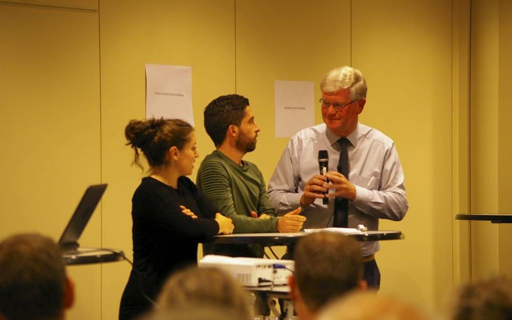 Jan Bouw (r.) ging donderdagavond tijdens een bijeenkomst in Barneveld in gesprek met twee christelijke vluchtelingen uit Damascus. beeld Georg Lindhoud