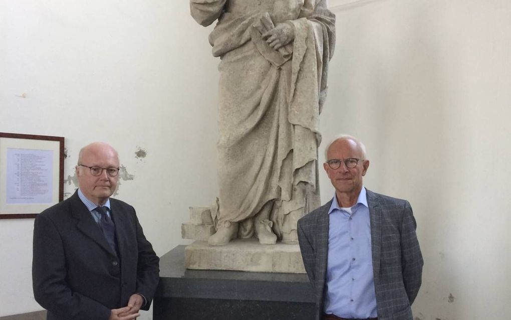 Dr. H. Uil (l.) en Kees van Walsem voor het beeld van Jacob Cats in de Nicolaaskerk in Brouwershaven. beeld RD