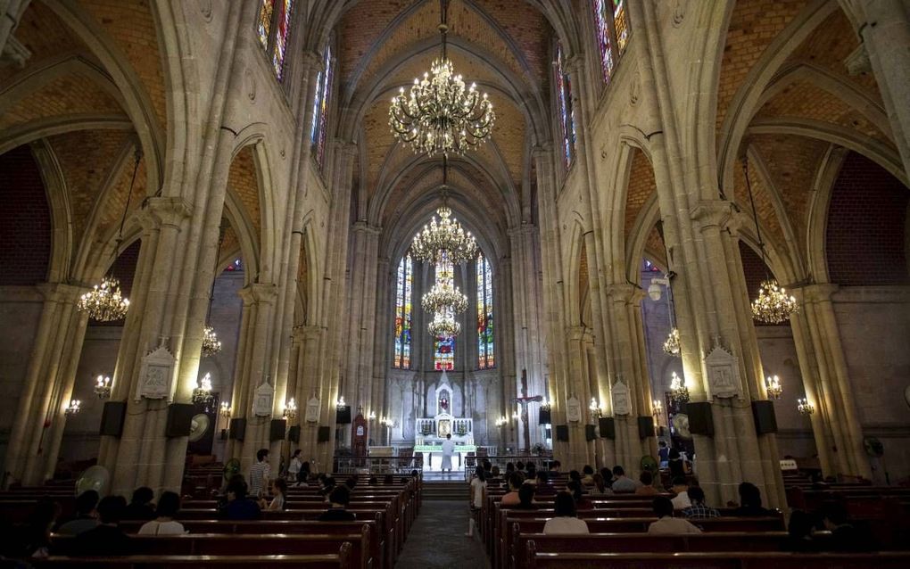 Toeristen en kerkgangers in de rooms-katholieke Heilig Hartkathedraal in Guangzhou. beeld AFP, Johannes Eisele