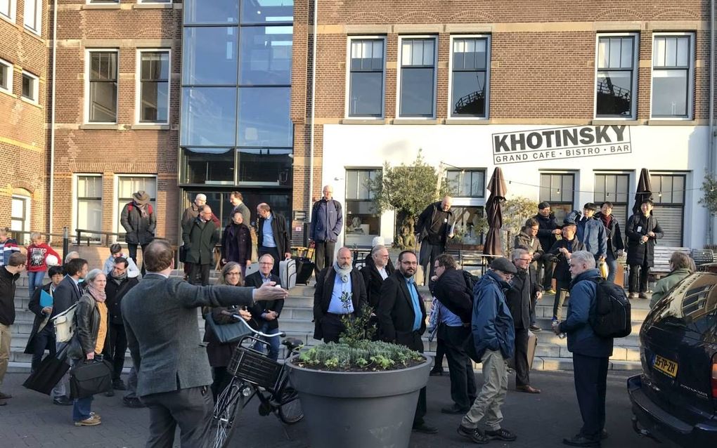 Bezoekers van een internationaal congres over de Synode van Dordrecht –in het Energiehuis in Dordrecht– maken zich gereed voor een excursie. beeld RD