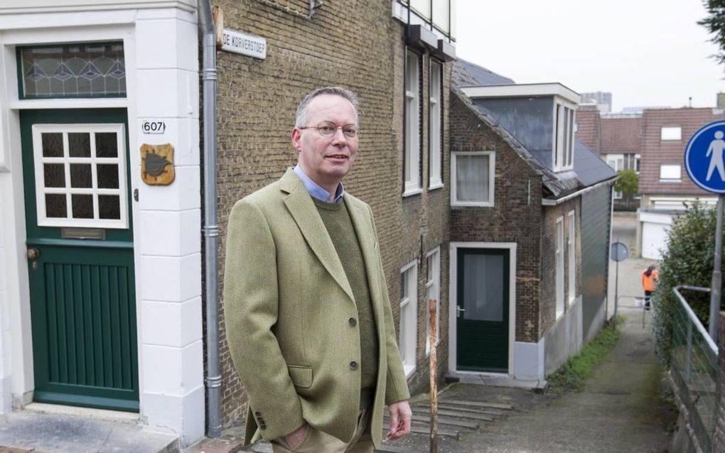 De geschiedfilosoof dr. Ewald Mackay (54) voor zijn geboortehuisje, rechts halverwege De Korverstoep, een steeg die dwars op de Rivierdijk in Sliedrecht staat. beeld RD, Anton Dommerholt