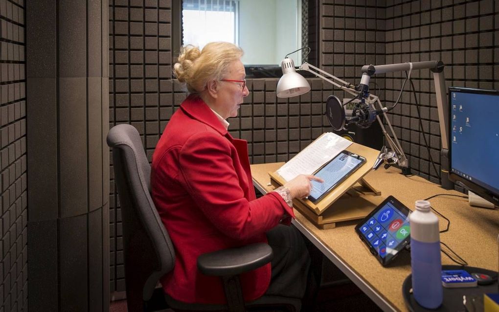 Geertje Cornelisse leest wekelijks in een studio het Reformatorisch Dagblad in voor blinden en slechtzienden. beeld RD, Henk Visscher