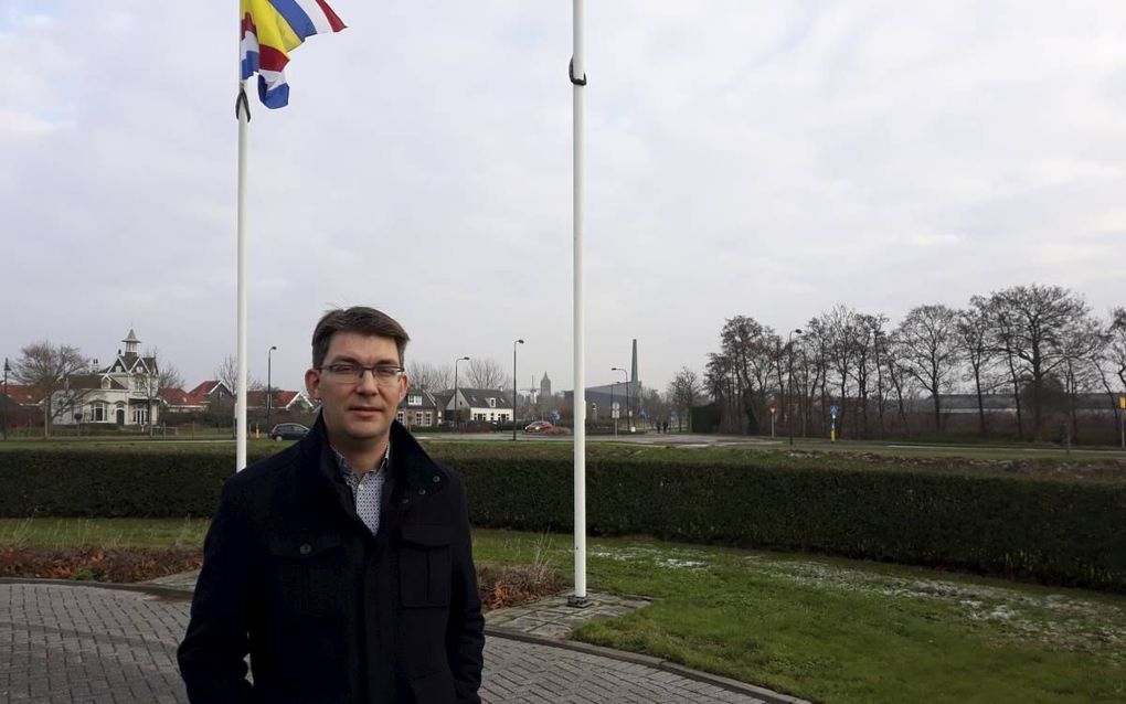 Peter Kraamer voor het gemeentehuis in Tholen. Op de achtergrond (r.) de plaatselijke gereformeerde gemeente. beeld RD