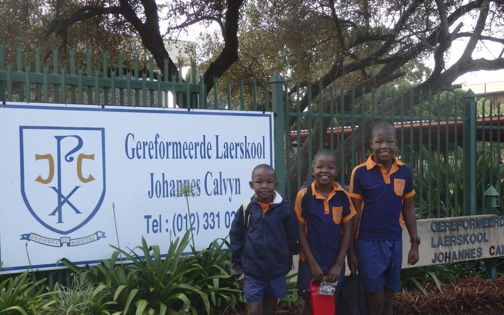 De kinderen Mnisi bij de school. Korah (l.), George Junior (m.) en Theophilus (r.). De ‘Calvyn’ is een particuliere christelijke school in Pretoria. beeld RD, Evert van Vlastuin