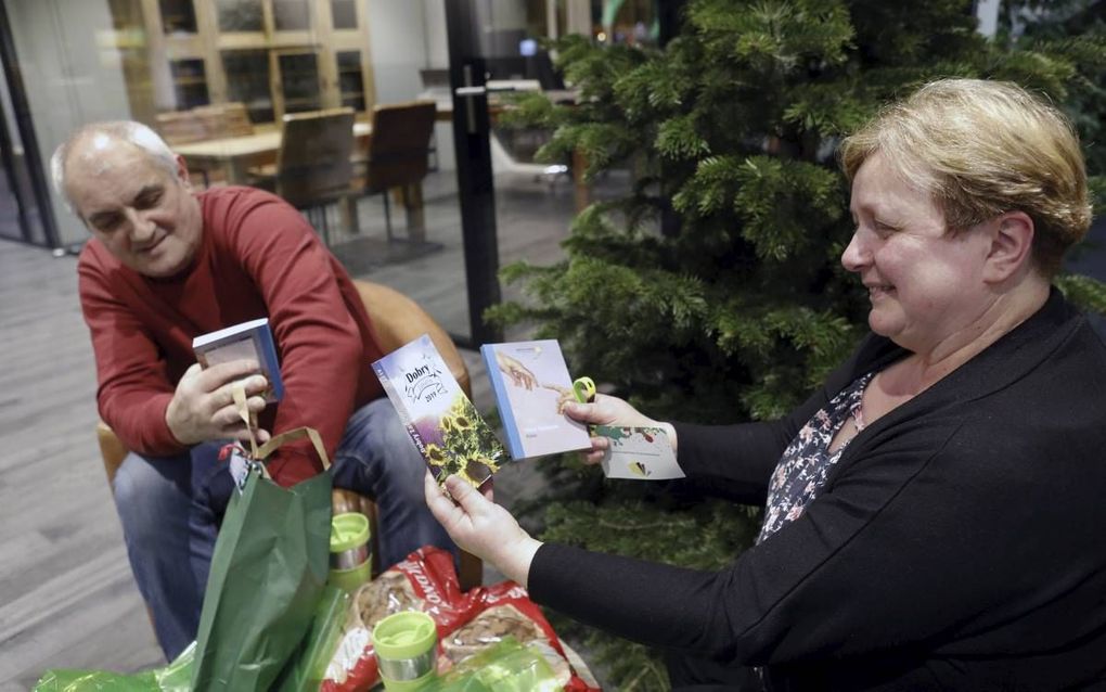 Verwonderd en aangenaam verrast bekijkt het Poolse echtpaar Marian (l.) Wiecha en Inga (r.) Najgebauer de inhoud van hun eindejaarspakket.  beeld Vidiphoto