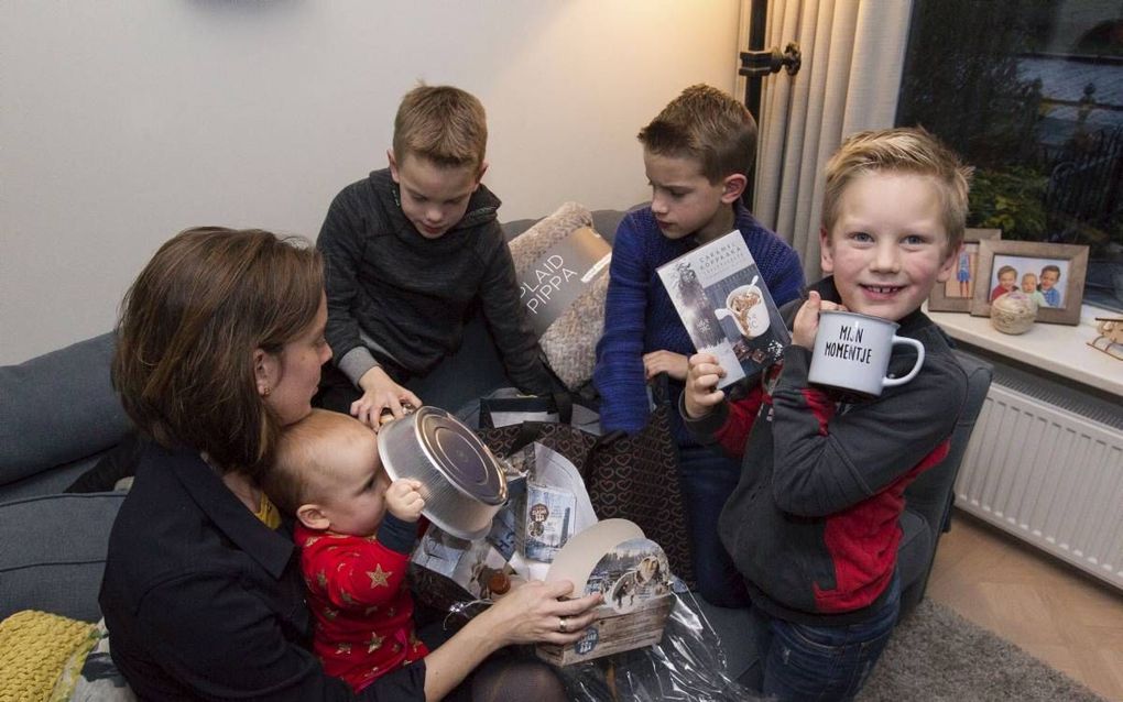 Esther van Es uit Woerden pakt met haar kinderen twee eindejaarspakketten uit. V.l.n.r.: Esther (36), Jade (0), Ruben (8) en Floris (10) en Judah (6).  beeld RD, Anton Dommerholt