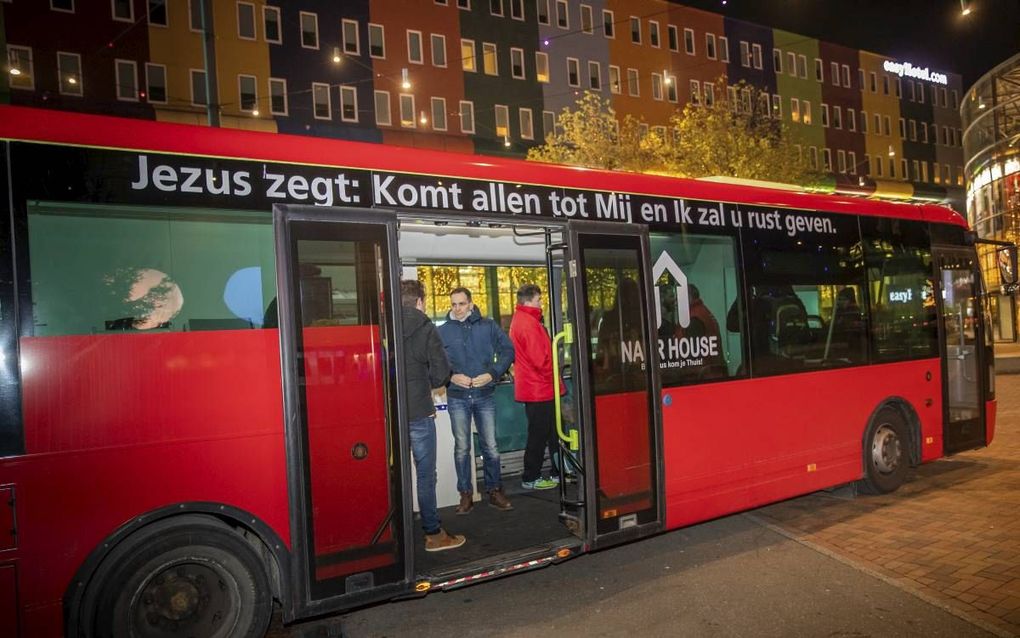 De evangelisatiebus van stichting Naar House, geparkeerd voor de deur van concertzaal AFAS live. beeld Martin Mooij