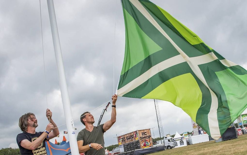 Stefan Groothuis (r) en ontwerper Paul Heutinck hijsen vorig jaar voor het eerst de Achterhoekse vlag. beeld De Feestfabriek, Martijn Koolmees