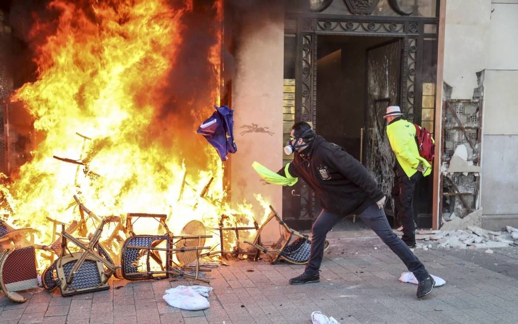 ‘Gele hesjes’ brachten zaterdag op de Champs-Elysées in Parijs grote vernielingen aan. Het was zaterdag de achttiende keer dat de in oktober ontstane protestbeweging een nationale protestdag hield. beeld AFP, Zakaria Abdelkafi