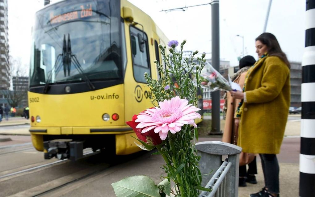 Bij de halte vlak bij de plaats waar maandag de schietpartij plaatshad in een tram, laten mensen bloemen achter.  beeld AFP, John Thys