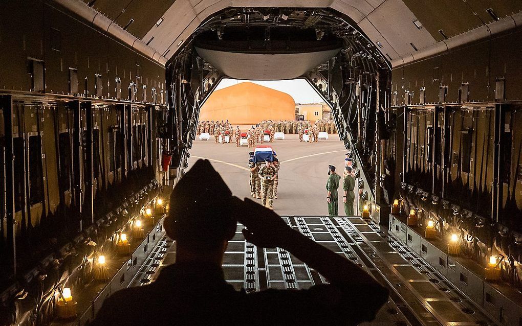 Een kist met daarin het lichaam van een omgekomen Franse militair wordt aan boord van een vliegtuig gebracht. Door een ongeval met twee helikopters in Mali kwamen vorige week dertien Franse militairen om het leven. De toestellen botsten op elkaar tijdens 