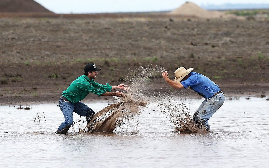 De buren James Purshouse (L) en Jock Tudgey vieren dat het heeft geregend in de Australische regio Liverpool Plains (New South Wales). beeld AFP