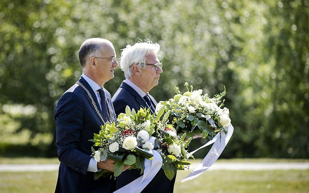 Burgemeester Onno van Veldhuizen (l.) en voorzitter van de Stichting Herdenking Vuurwerkramp Bram Distel leggen bloemen bij een monument, tijdens de herdenking van de vuurwerkramp. beeld ANP