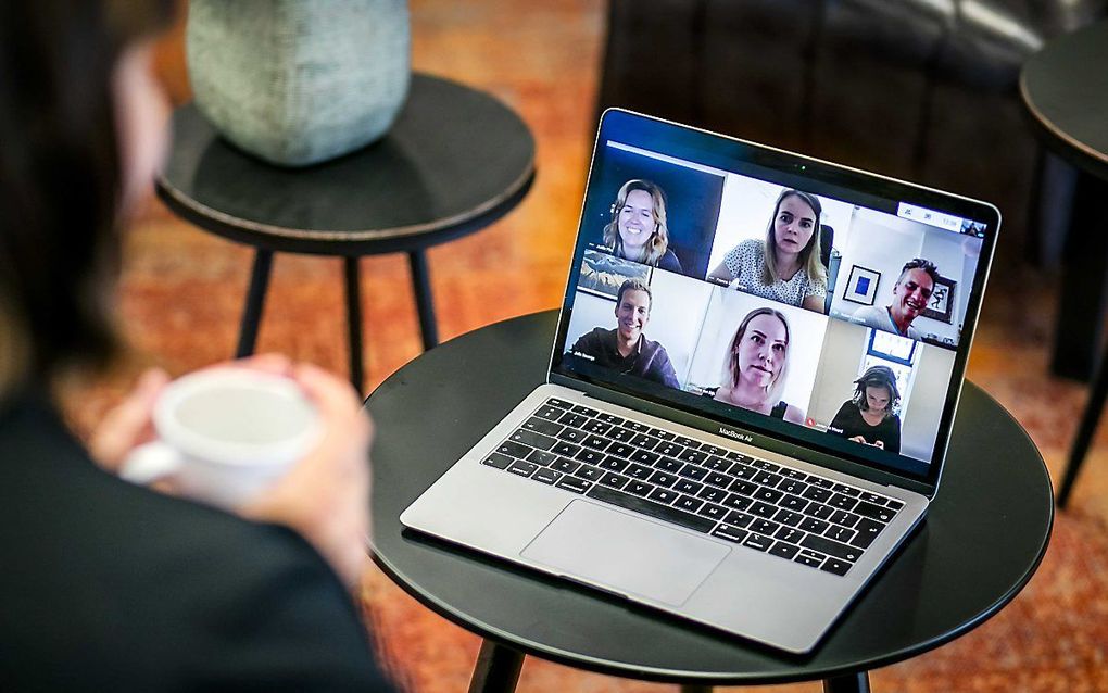 Videobellen met thuiswerkende collega's om te overleggen over het werk. beeld ANP, Remko de Waal