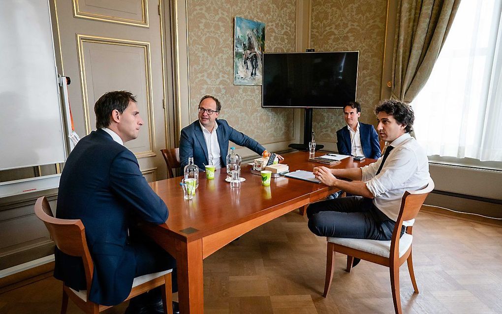 Minister Wopke Hoekstra van Financiën (CDA) en Minister Wouter Koolmees van Sociale Zaken en Werkgelegenheid (D66) in gesprek met Paul Smeulders (Groenlinks) en Jesse Klaver (Groenlinks) over het economische steunpakket van het kabinet voor corona. beeld 