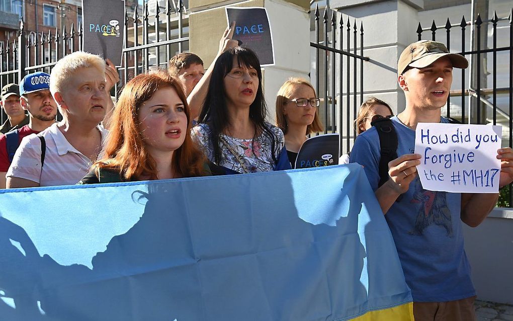 Demonstranten tegen de terugkeer van Rusland in de Raad van Europa voor de Oostenrijkse ambassade in Kiev, dinsdag. beeld AFP, Sergei Supinksy