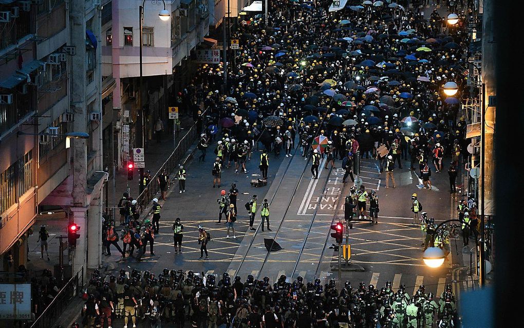 Demonstranten tegenover oproerpolitie (beneden in beeld) in Hongkong, afgelopen weekend. beeld AFP, Anthony Wallace