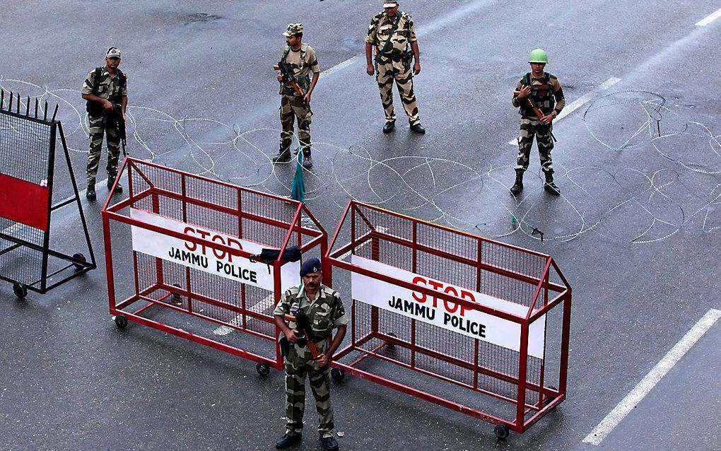 Indiase veiligheidstroepen houden wacht bij een wegblokkade in Kasjmir. Premier Modi wil onlusten voorkomen. beeld AFP, Rakesh Bakshi