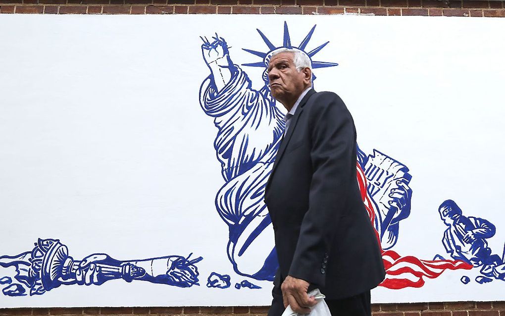 Een Iraniër loopt langs een schildering op een muur van de voormalige Amerikaanse ambassade in Teheran. beeld AFP