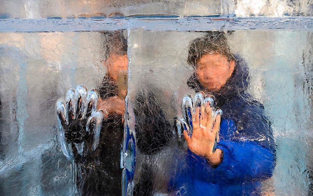 Een man laat zijn handdruk achter in de ”Ice Maze", het grootste ijsdoolhof van de VS in Washington D.C. beeld AFP