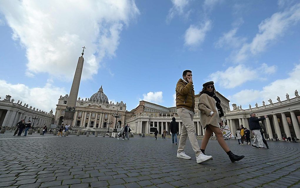 Toeristen lopen vrijdag op een verlaten St. Pietersplein in Rome. beeld AFP,  Vincenzo Pinto