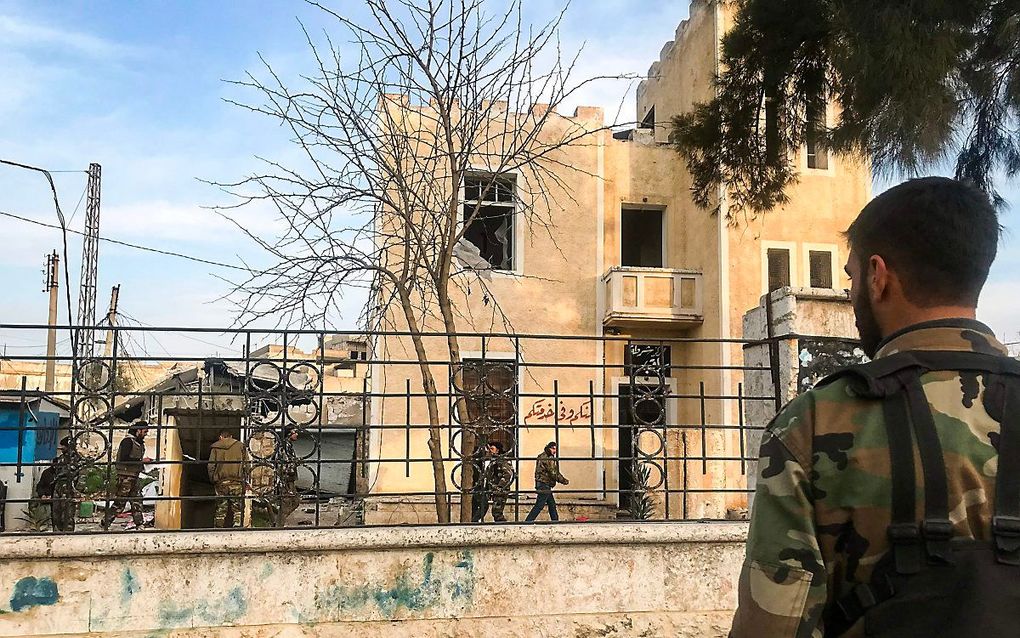 Een Syrische militair inspecteert in Saraqib, in de provincie Idlib, een gebouw dat werd door rebellen werd gebruikt als politiebureau. beeld AFP