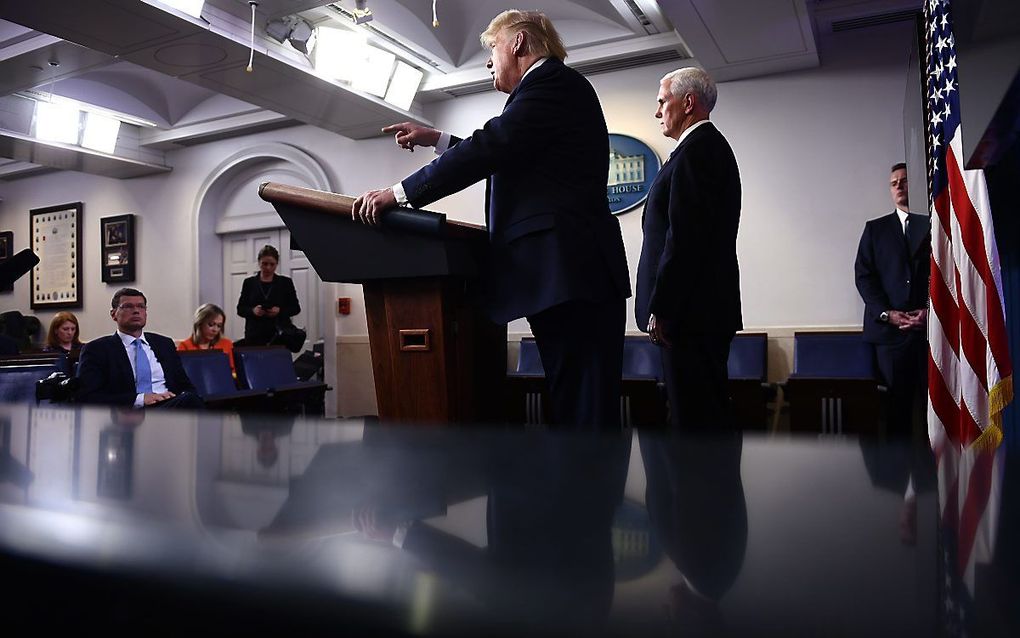 De Amerikaanse president Trump (l.), geflankeerd door vice-presicent Pence, tijdens zijn dagelijkse persconferentie over de strijd tegen het coronavirus. beeld AFP, Brendan Smialowski