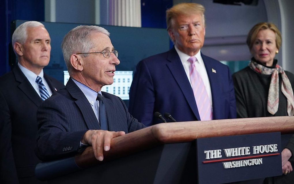 De Amerikaanse president Trump is het niet eens met de waarschuwing van immunoloog Anthony Fauci (l.) om de Amerikaanse economie niet te snel te heropenen. beeld AFP