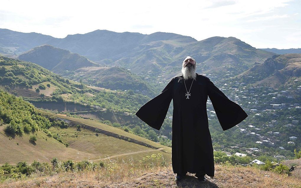 De orthodoxe priester Ter Abel bidt voor vrede bij het dorp Movses aan de grens van Armenië en Azerbeidzjan. beeld AFP