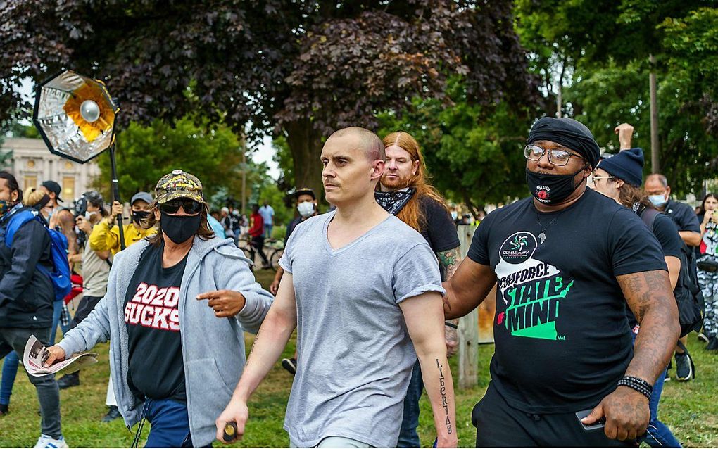 Een gewonde aanhanger van Trump te midden van demonstranten in Kenosha (Wisconsin). beeld AFP, Kerem Yucel