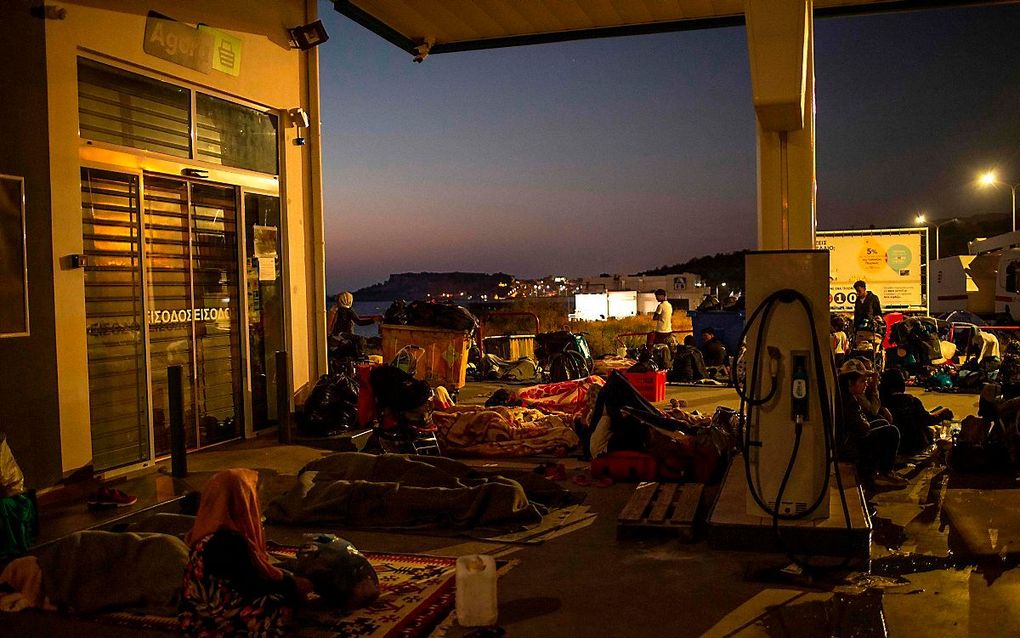 Asielzoekers slapen bij een tankstation bij Mitylini, de hoofdstad van Lesbos. beeld AFP, Angelos Tzortzinis