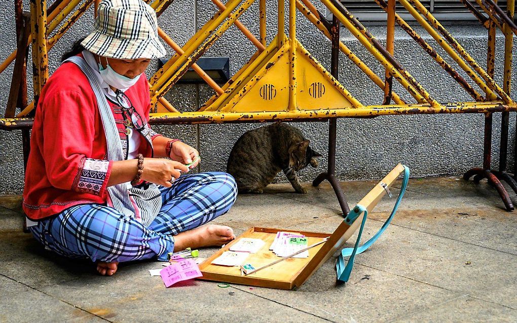 Straatverkopers, zoals deze vrouw in de Thaise hoofdstad Bangkok, zijn uitermate kwetsbaar in perioden van strenge maatregelen tegen het coronacrisis. beeld AFP, Mladen Antonov