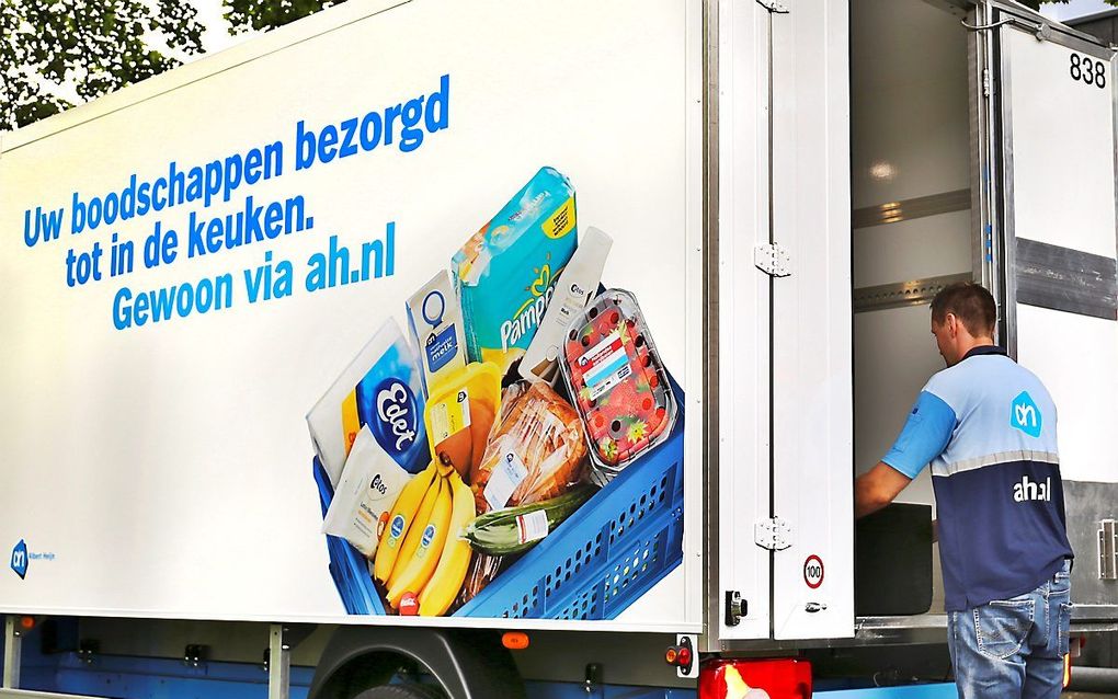 Een medewerker van de Albert Heijn bezorgt een doos met ingrediënten voor een maaltijd. Steeds meer mensen bestellen online, meldde het CBS maandag. beeld ANP, Stephan van den Bos