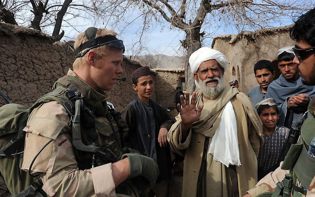 Nederlandse militairen in gesprek met de bewoners van de Choravallei in Uruzgan, Afghanistan in 2010. beeld AFP